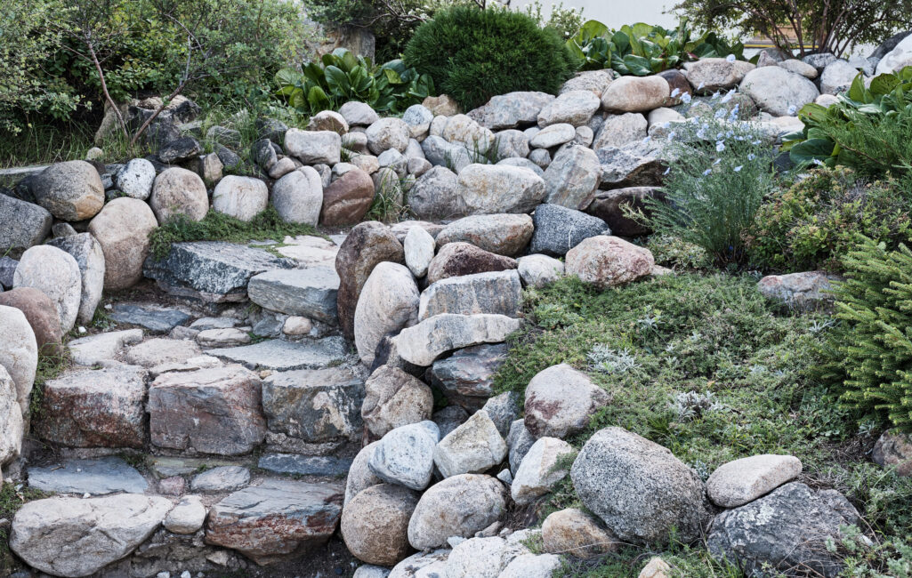 Steps made of large stones. Staircase up in landscape composition. Japanese rock garden. Buddhist datsan Rinpoche Bagsha, Ulan-Ude, Russia.